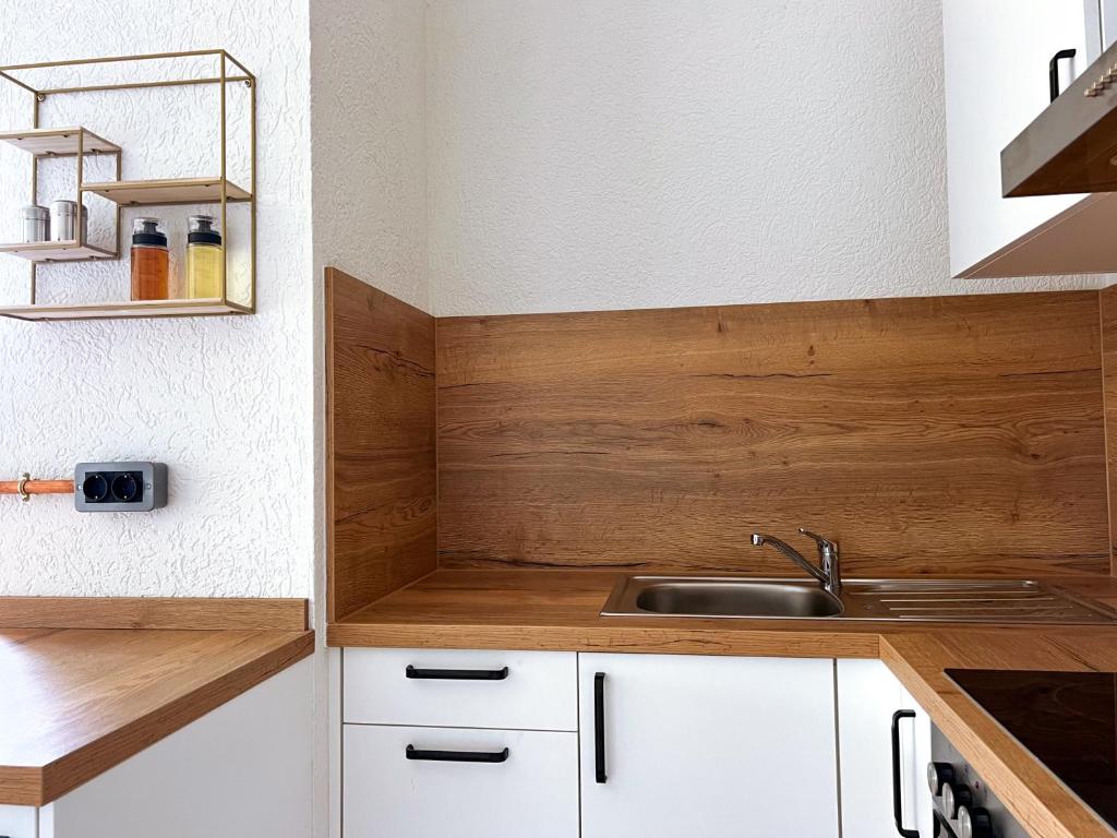a kitchen with white cabinets and a sink at Nomad Nest in Michelbach an der Bilz