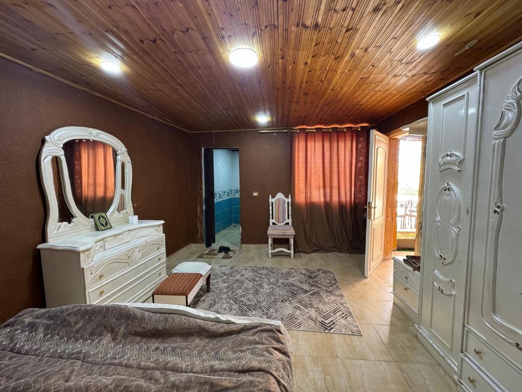 Schlafzimmer mit einem Bett, einer Kommode und einem Spiegel in der Unterkunft شاليه البحر الميت الرامة-Deadsea in Al Rama