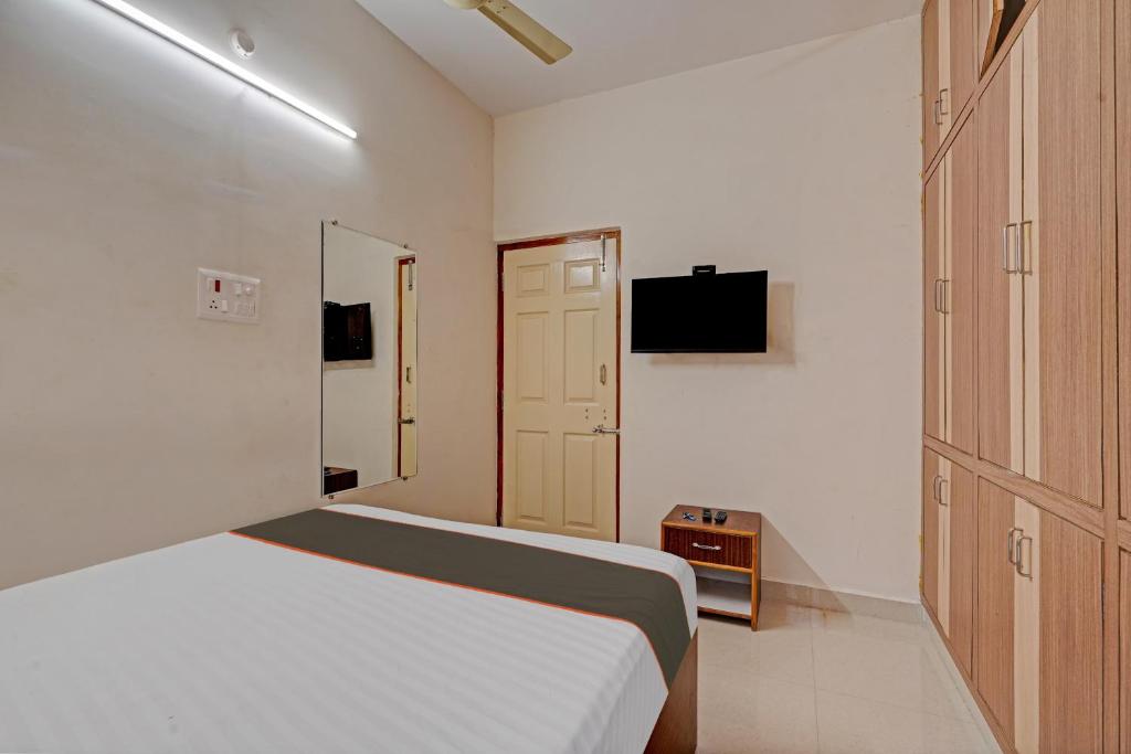 a small bedroom with a bed and a television at Collection O Ns Service Apartment in Tirupati