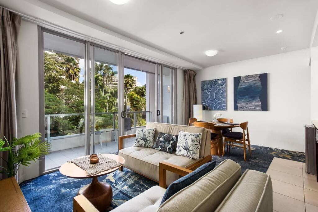 sala de estar con sofá y mesa en Absolute Waterfront - Enjoy Exceptional Lifestyle, en Cairns