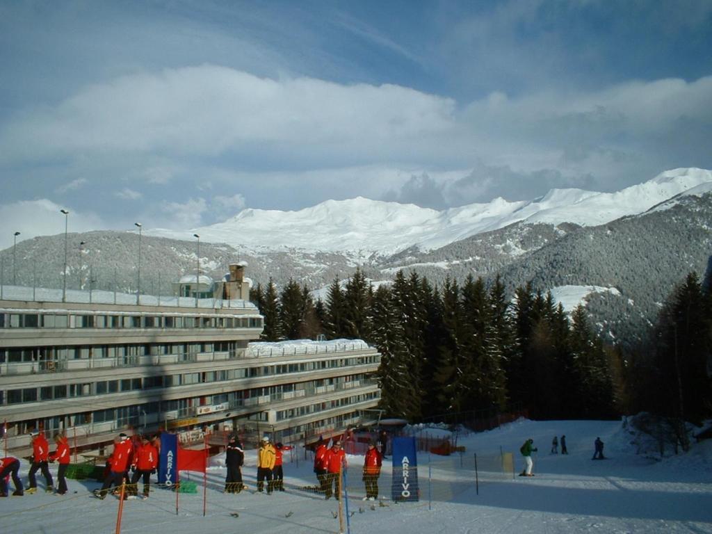 un grupo de personas esquiando frente a un edificio en Appartamento Artuik, en Marilleva