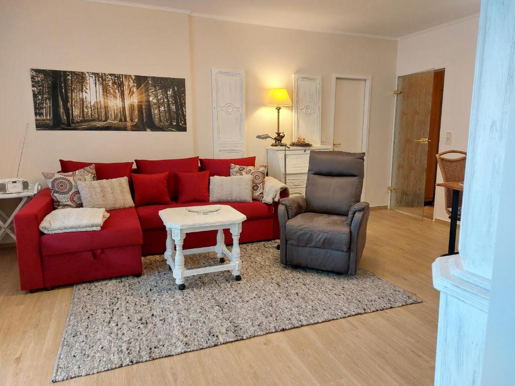 - un salon avec un canapé rouge et une chaise dans l'établissement Ferienwohnung Am Alten Salzwerk 3a/44, à Bad Harzburg