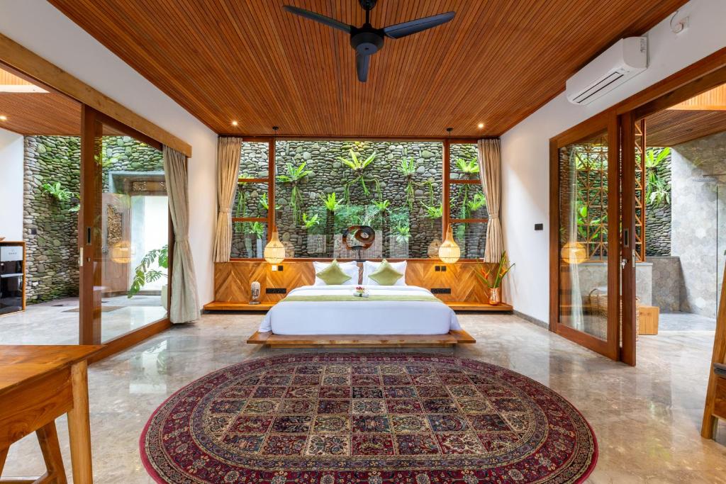 - une chambre avec un lit et une grande fenêtre dans l'établissement Villa Rabita, à Ubud