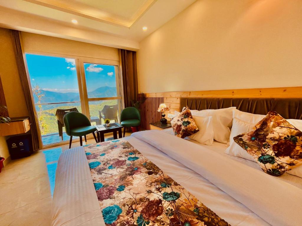 um quarto com uma cama grande e uma janela grande em The Pine Woods - A Four Star Luxury Resort in Mussoorie em Mussoorie