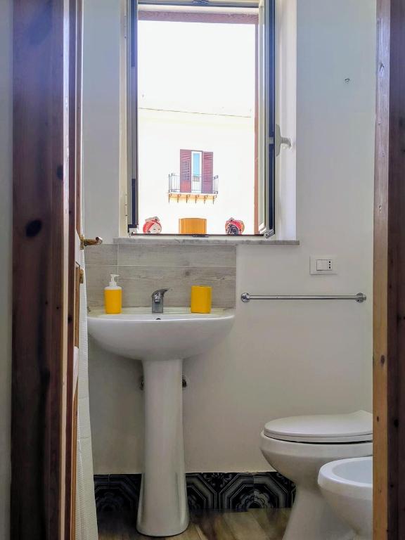 a bathroom with a sink and a toilet and a window at Loft le Due Effe al Capo in Palermo