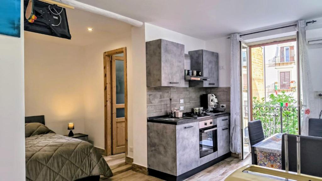 a room with a kitchen with a bed and a stove at Loft le dueffe al capo in Palermo