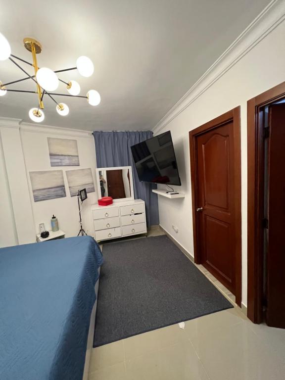 a bedroom with a blue bed and a television at Lagrande Home in La Grúa