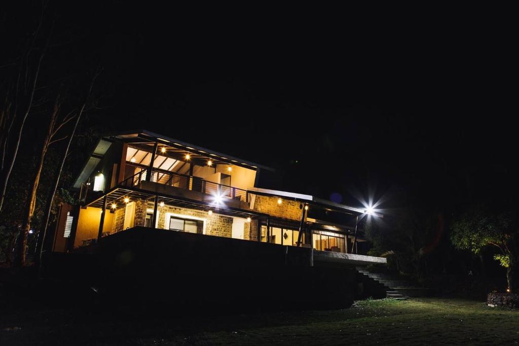 una casa iluminada por la noche con luces en Windy Bottom Villa, en Nashik