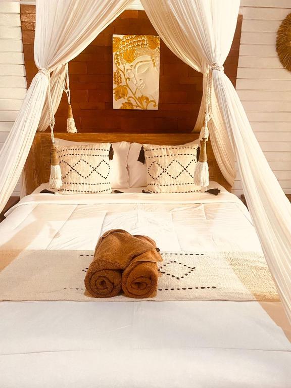 a bed with a pile of towels on it at La Nusa Penida Homestay by BIJAK in Nusa Penida