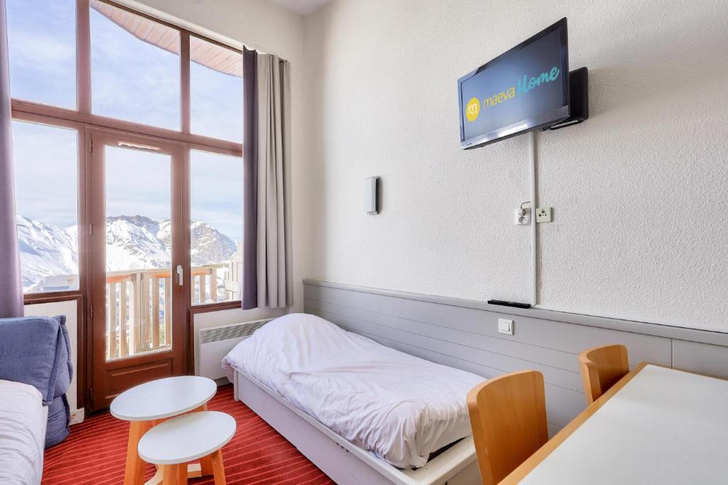 Habitación de hotel con cama y TV en la pared en Résidence Antarès - maeva Home - Appartement 2 pièces 4 personnes - Prest 214, en Avoriaz
