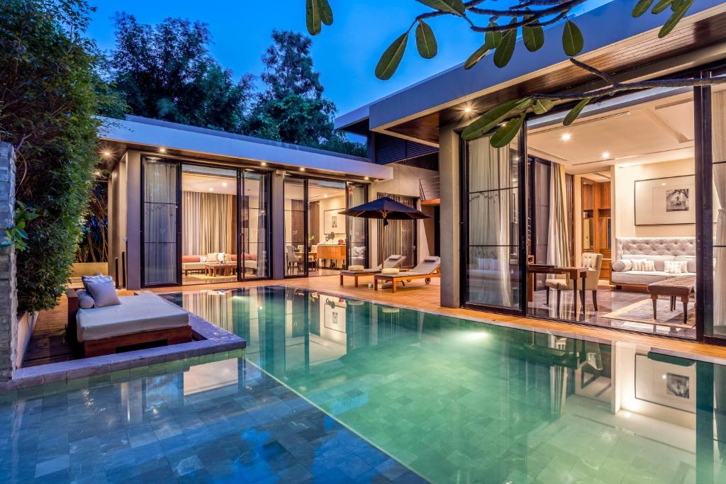 uma piscina de beiral infinito numa villa com uma sala de estar em V Villas Hua Hin, MGallery em Hua Hin