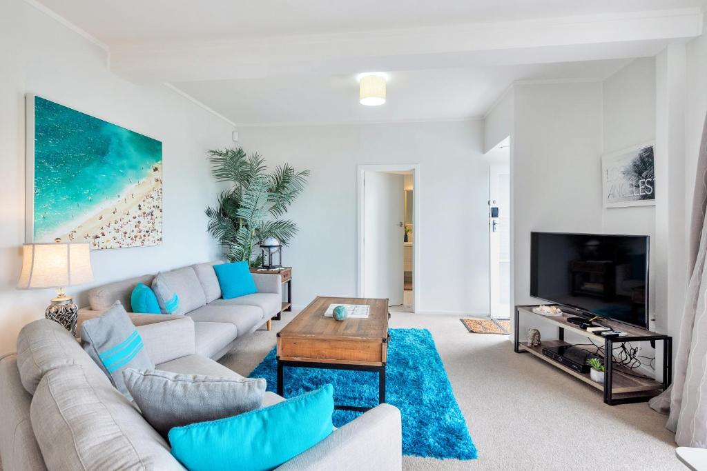 uma sala de estar com um sofá e uma mesa em Bright Kingsland Contemporary em Auckland