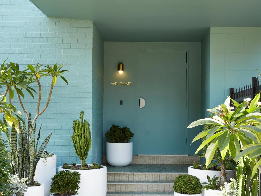 a blue front door with plants in front of it at Green Valley Hotel in Mount Pritchard