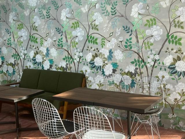 a table and chairs in front of a floral wall at 三浜館 伊豆大島 in Oshima