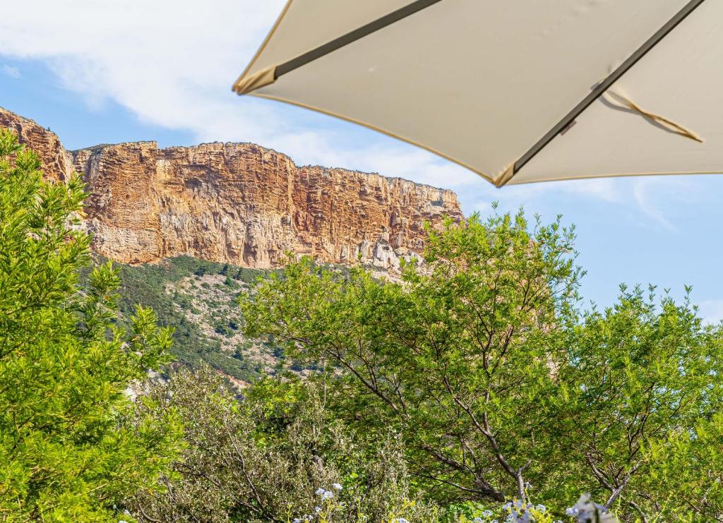 une vue d'une montagne sous un parapluie dans l'établissement Le Dar el Chott par Dodo-à-Cassis, à Cassis