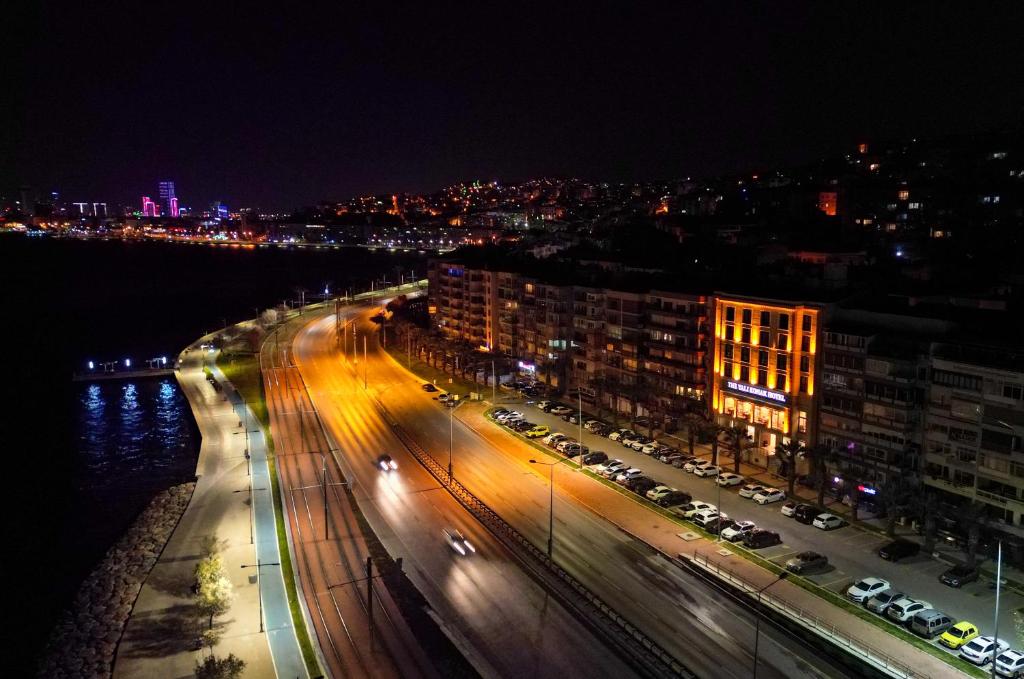 nachts eine Stadtstraße mit Autos und Gebäuden in der Unterkunft The Yalı Konak Hotel İzmir in Izmir