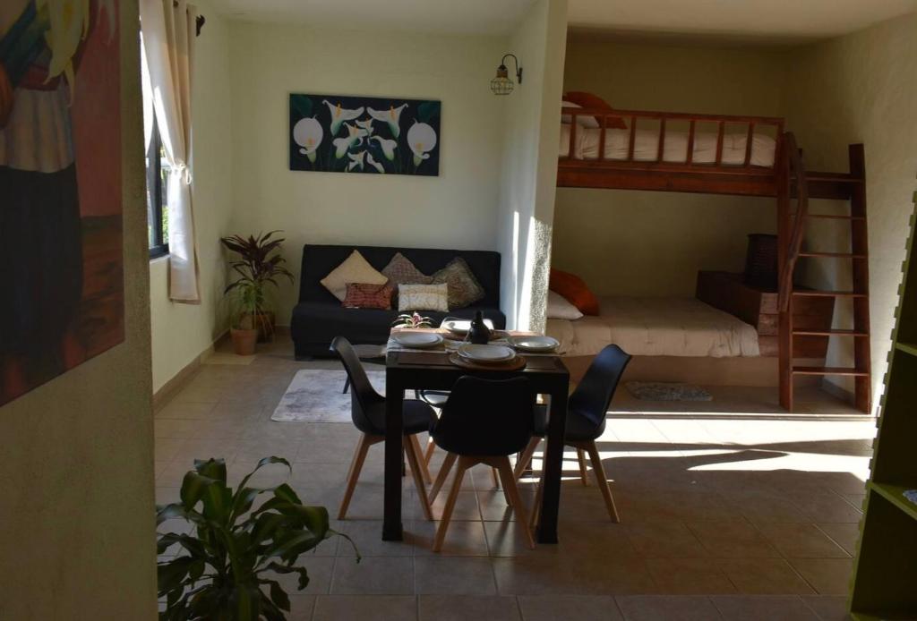 uma sala de estar com uma mesa e cadeiras e uma cama em Los Alcatraces em Valle de Bravo