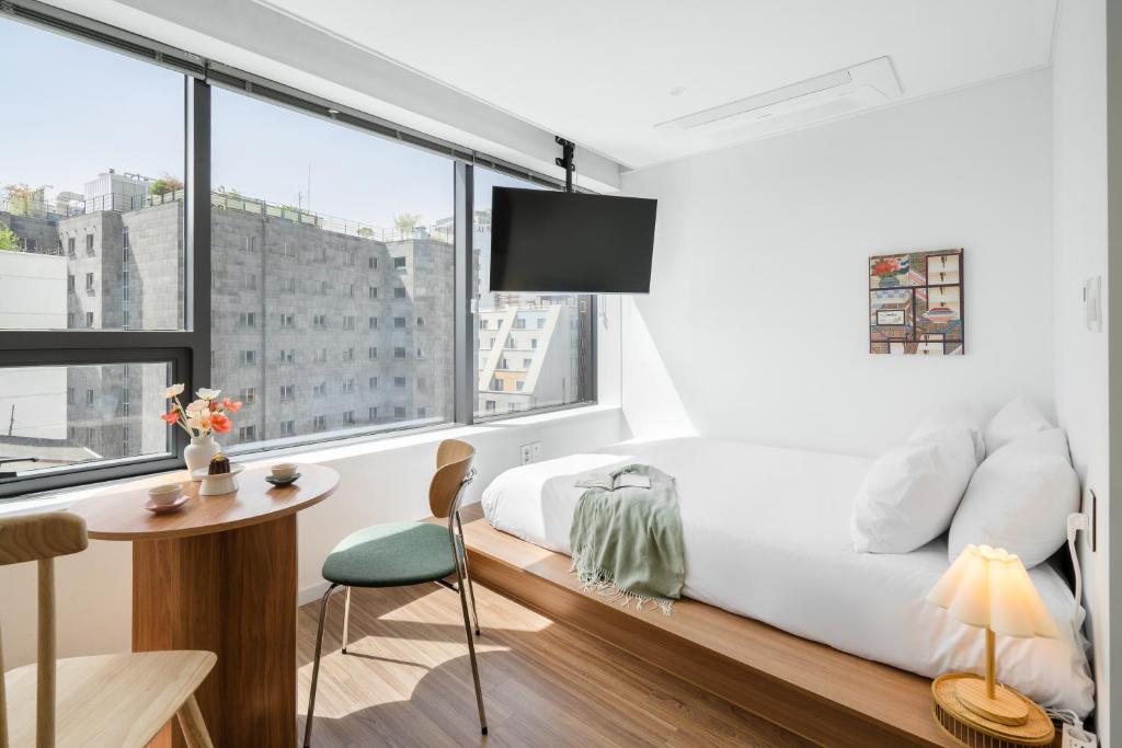 1 dormitorio con cama, escritorio y ventana en Urbanstay Boutique Ikseon en Seúl