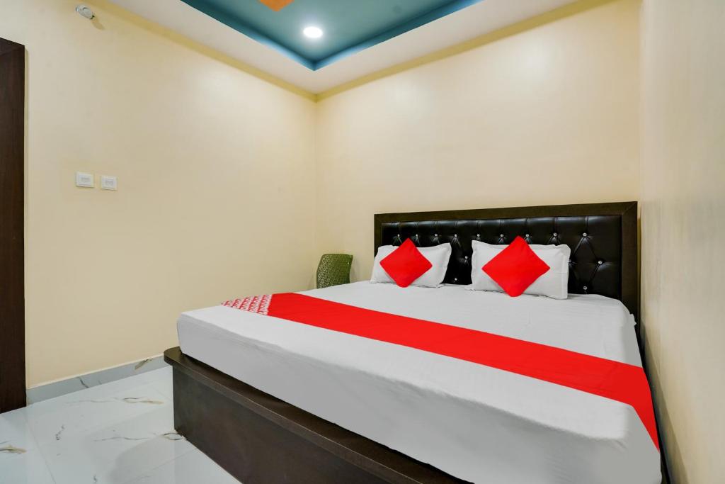 a bedroom with a large bed with red pillows at OYO Flagship Heritage Farm Resort in Itwāri
