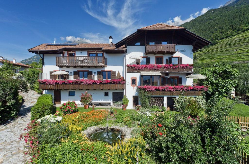 ein Gebäude mit Blumen vor einem Garten in der Unterkunft Humblhof in Algund