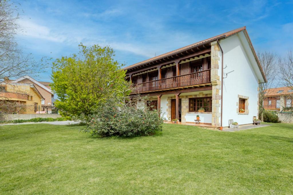 ein Haus mit einem Balkon und einem Hof in der Unterkunft Casa Montañesa in El Astillero
