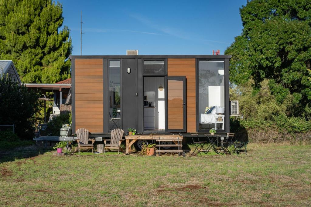 a tiny house with a table and chairs in a yard at Campbells Cottage - Farm Stay Victoria 