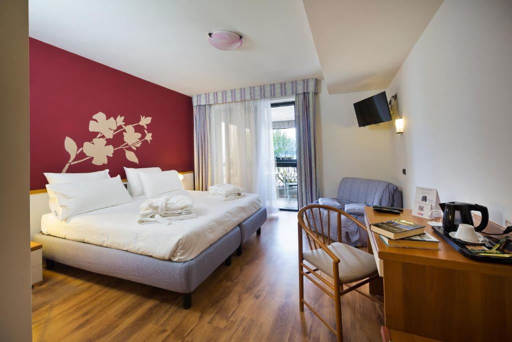 Een bed of bedden in een kamer bij Alevic Hotel Sirmione