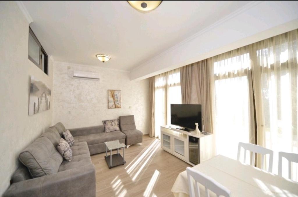 ein Wohnzimmer mit einem Sofa und einem TV in der Unterkunft Langust - free parking in Sveti Stefan