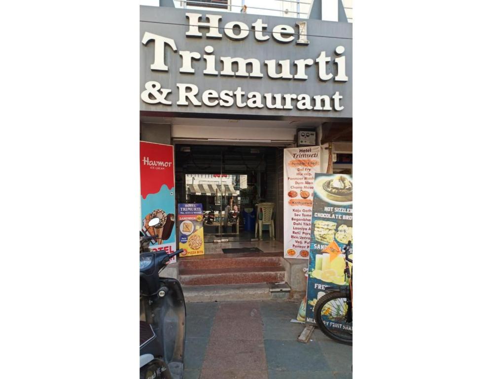 una marca de hotel y de restaurante frente a un edificio en Hotel Trimurti, Dwarka, en Dwarka