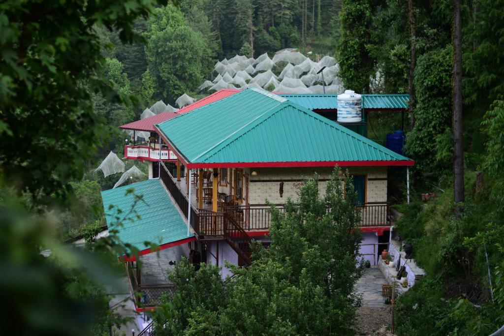 una casa con techo verde en una montaña en Zen Homestay en Cheog