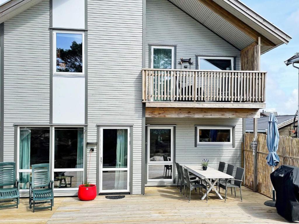 a house with a deck and a table and chairs at Holiday home Vesterøy II in Rød
