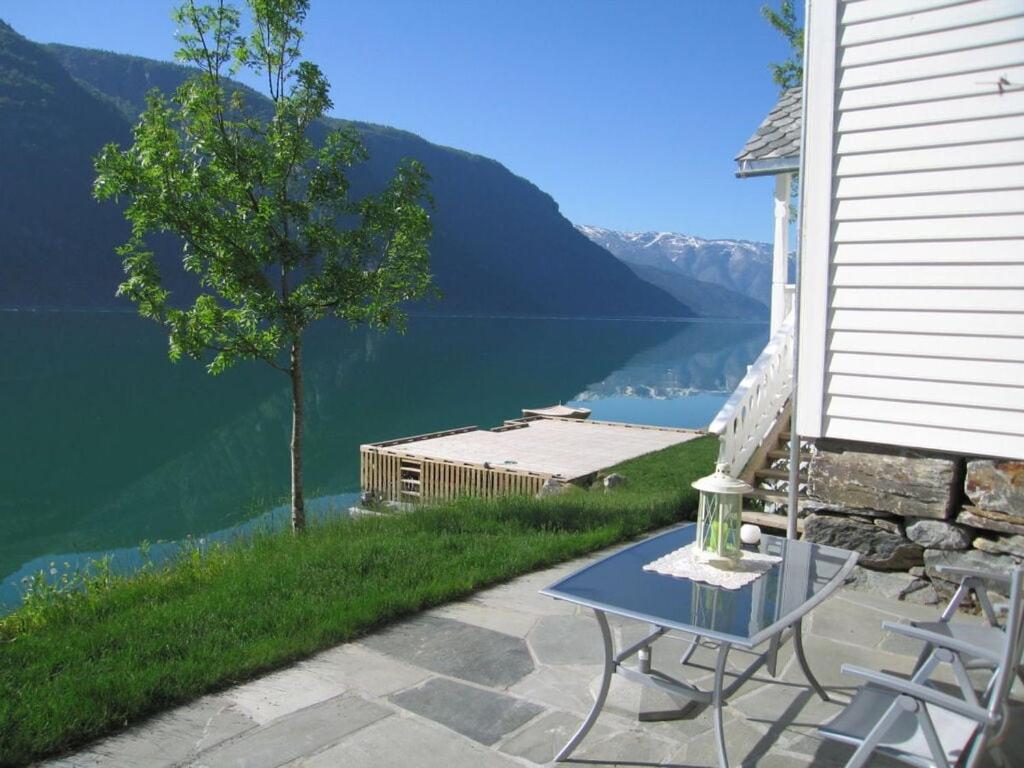a table and chairs on a patio with a view of a lake at "Butikken" - sea cabins in Ulvik