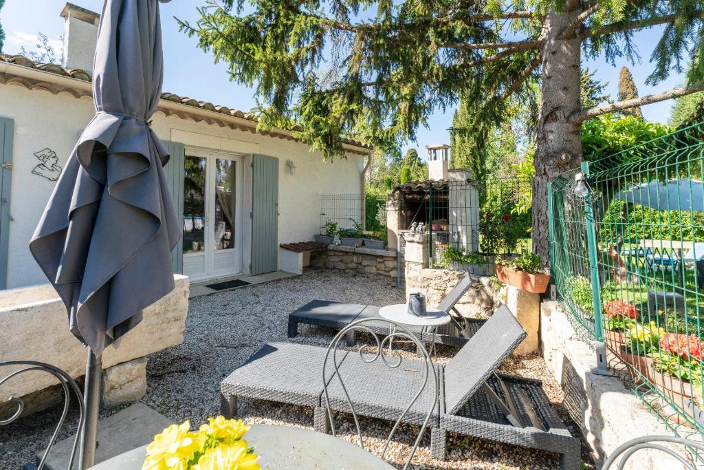 une terrasse avec un parasol, une table et des chaises dans l'établissement Appartement agréable en Provence, à Saint-Rémy-de-Provence