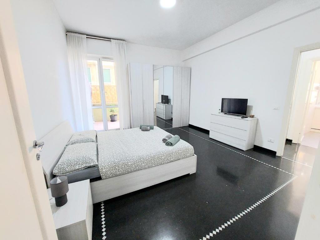 a white bedroom with a bed and a tv at Home Cristina in Genova