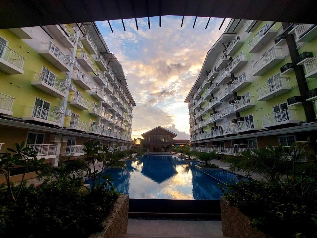 a view of a swimming pool between two apartment buildings at ANIA ROOMS@AMANI GRAND RESIDENCES NEAR AIRPORT in Mactan