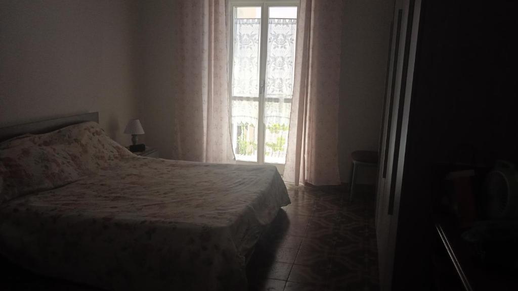ein Schlafzimmer mit einem Bett und einem großen Fenster in der Unterkunft Da Anto in Trivio
