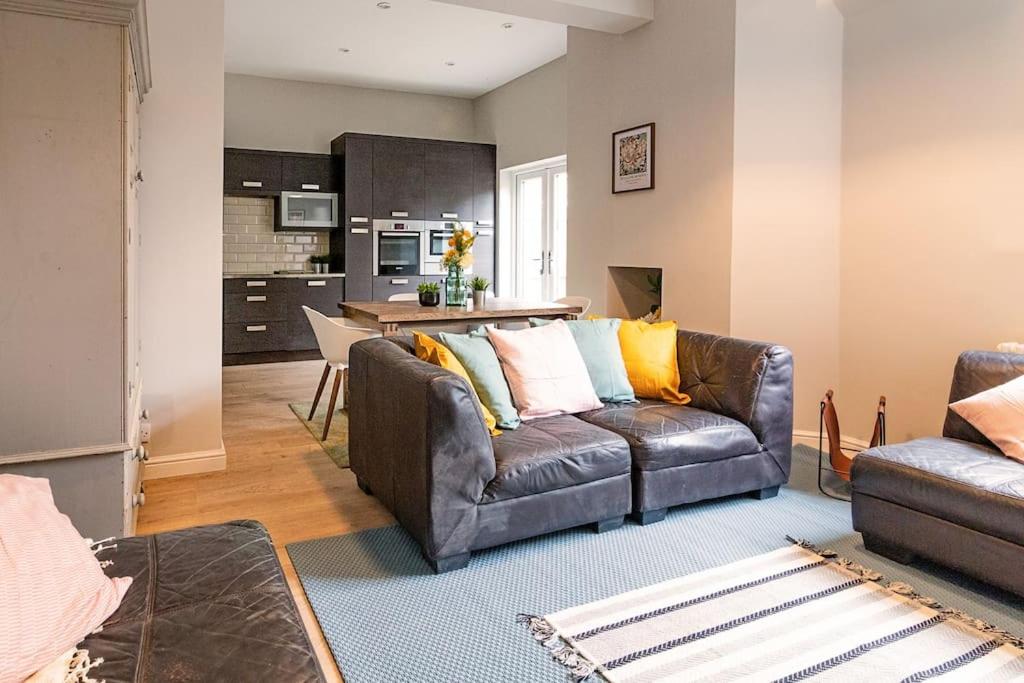 a living room with a couch and a kitchen at Chapel View in Loughborough