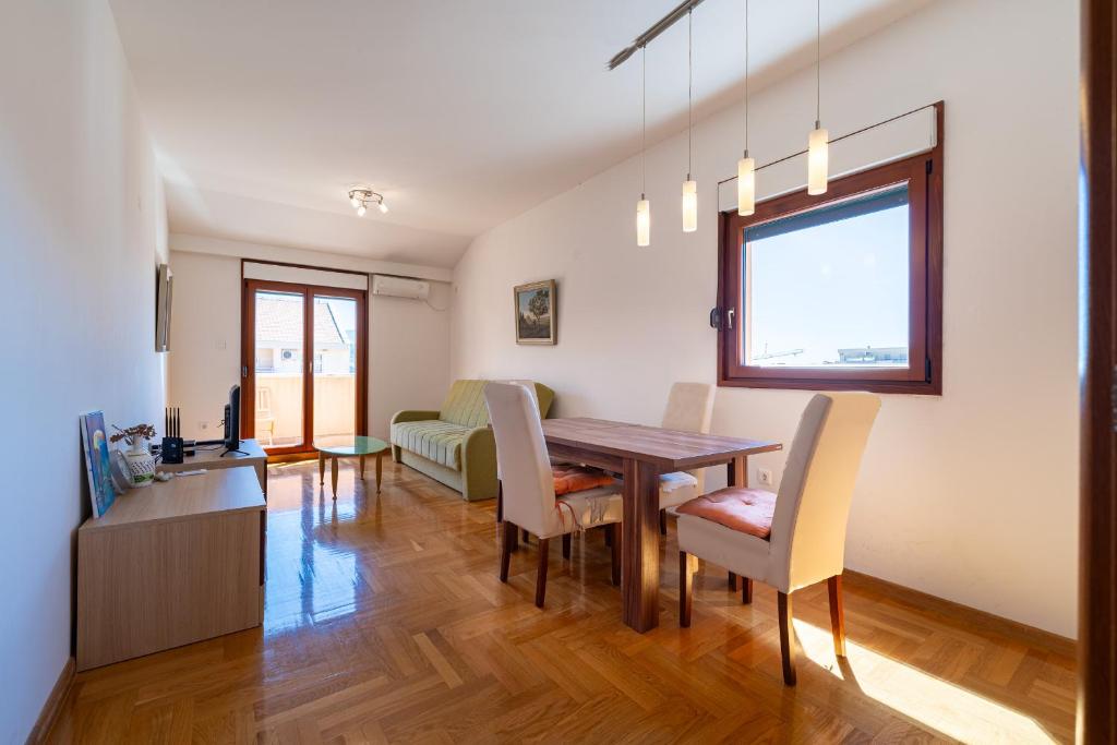 una sala da pranzo e un soggiorno con tavolo e sedie. di Family One bedroom apartment with Panoramic city view a Budua