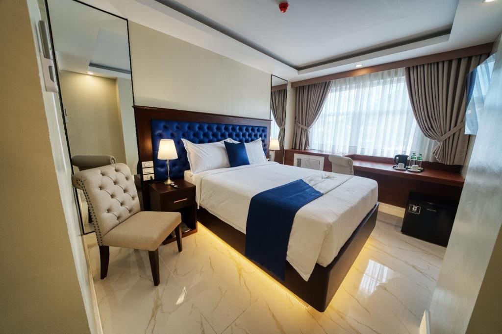 Habitación de hotel con cama y silla en Monaco Hotel en Taytay