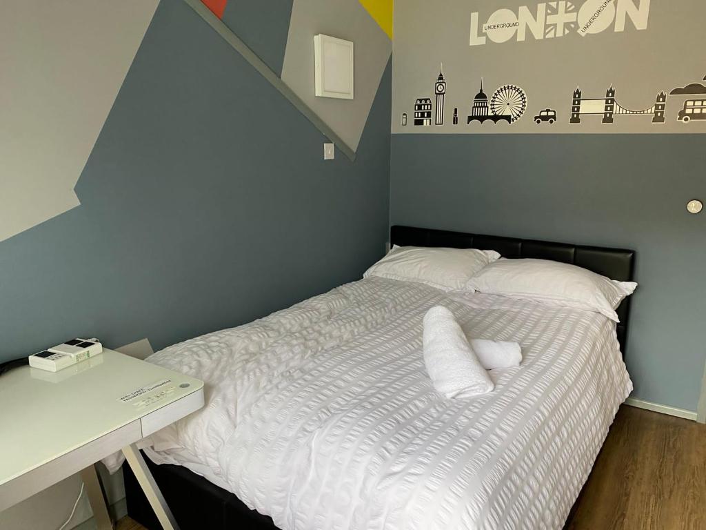 een slaapkamer met een bed met 2 kussens en een bureau bij Luxurious Soft Water Air Conditioning TV BITCOIN in Londen
