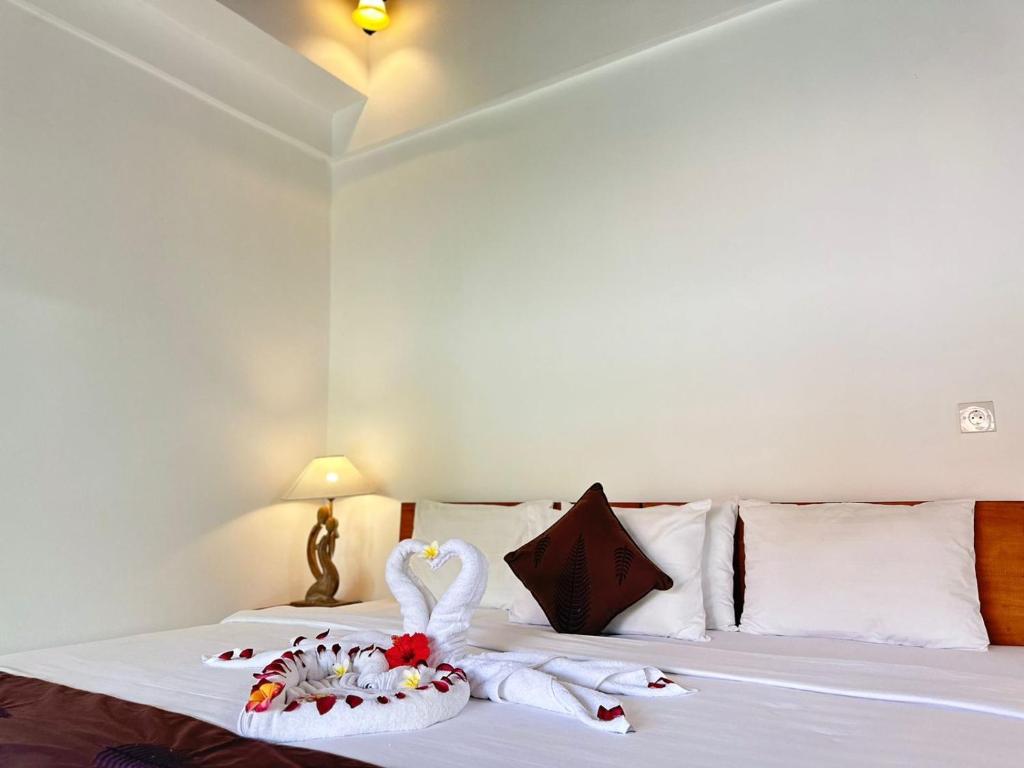a bedroom with a bed with swans towels on it at Bupon House Jepun Room in Gianyar