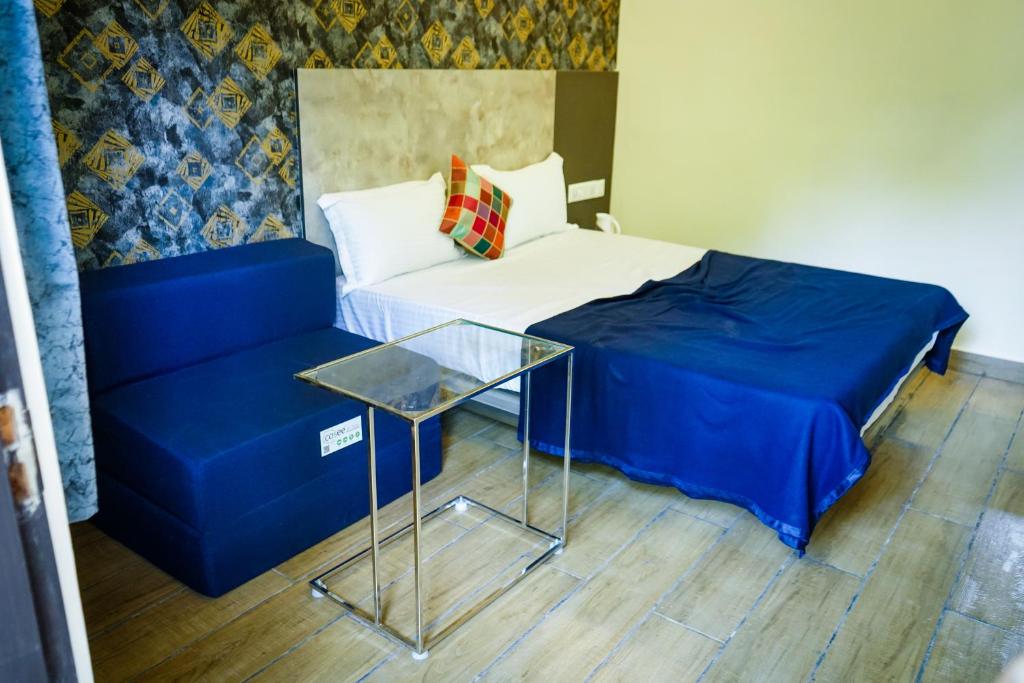 a bedroom with a bed and a glass table at Hotel Alpenglow in Yercaud