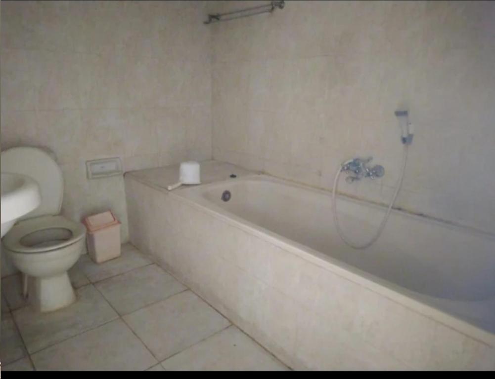 marini hotel في Colomadu: حمام مع مرحاض وحوض استحمام ومغسلة