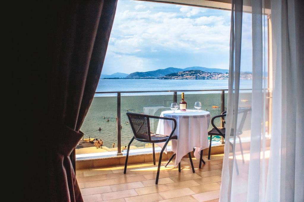 Park Lakeside Ohrid في أوخريد: شرفة مع طاولة وكراسي وإطلالة على الشاطئ
