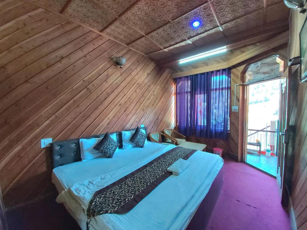 奈尼塔爾的住宿－Hotel Lake View Mall Road Nainital，卧室配有一张床铺,位于带木墙的房间内