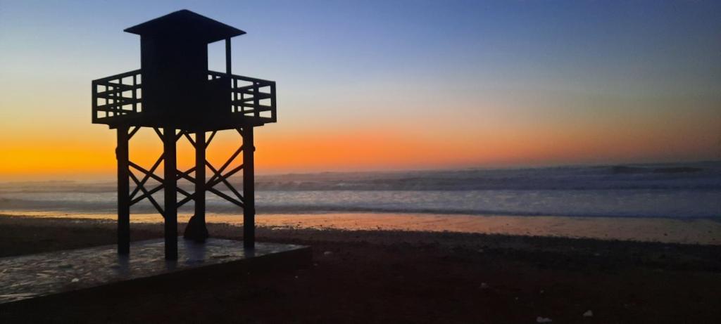 a lifeguard tower on the beach at sunset at Maison Xanadu in Sidi Ifni