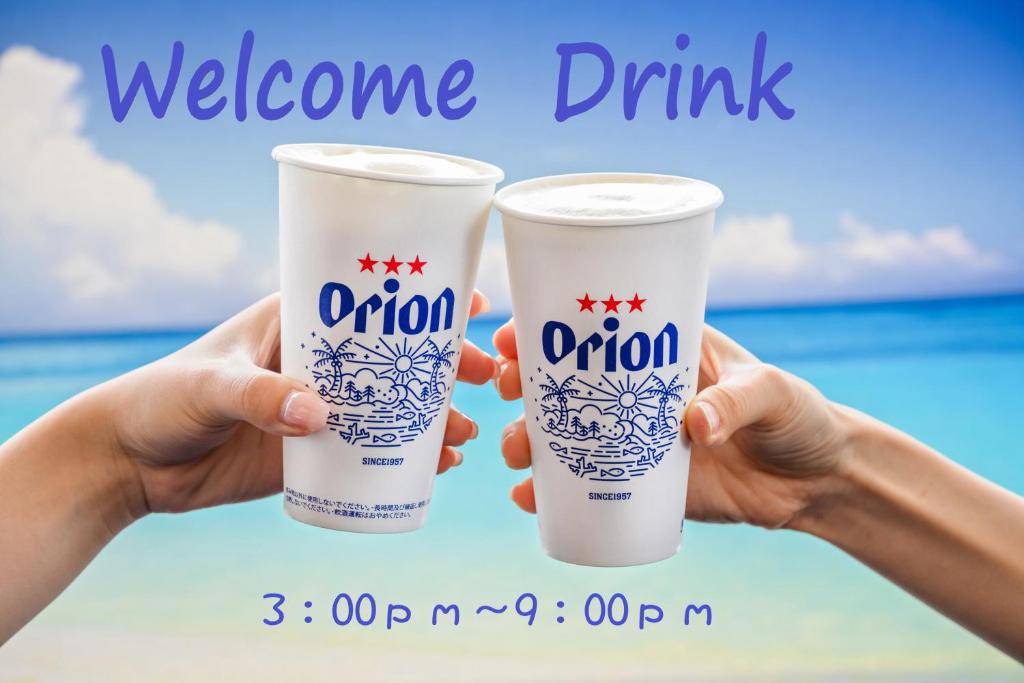 a pair of hands holding up two plastic cups at Toyoko Inn Okinawa Naha Asahibashi Ekimae in Naha