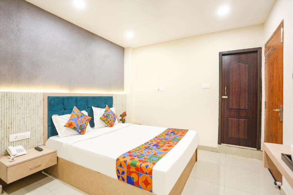 FabHotel Hari Kunj في فاراناسي: غرفة نوم فيها سرير وتلفون