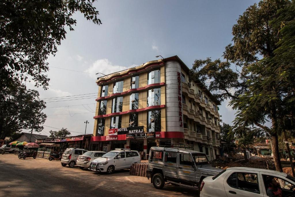 a tall building with cars parked in front of it at Hotel natraj pachmarhi in Pachmarhī