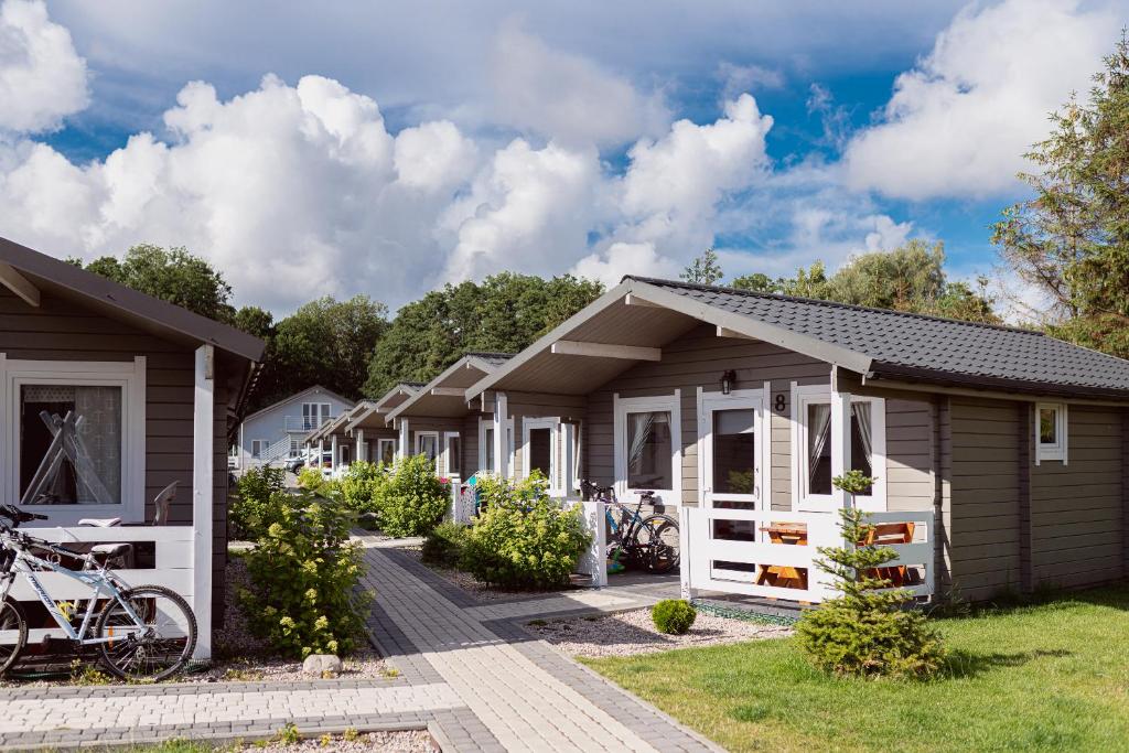 eine Reihe von Häusern mit Fahrrädern, die vor ihnen geparkt sind in der Unterkunft Chłopy Beach Resort in Chłopy